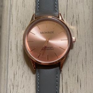 Rose gold watch face with gray leather band